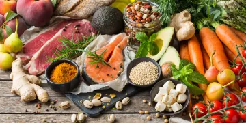 Assortment of grains, vegetables, fruits, and meats laid out on a table