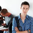 Young man standing alone in hallway