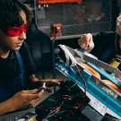 Two youth working on an industrial job site