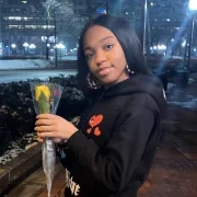 Photo of Kam holding a flower.