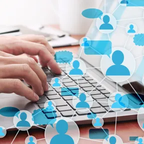 A web of people is shown over someone typing on a laptop