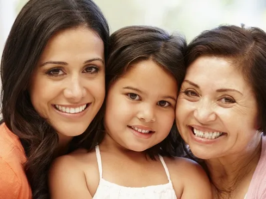 A mother, child, and grandmother smiling