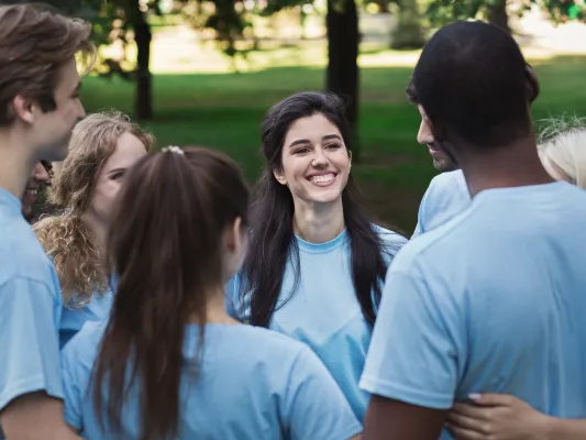 A young group of people talk in a group at a common event.