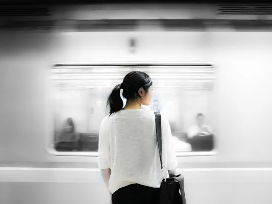 Woman waits for train in work attire