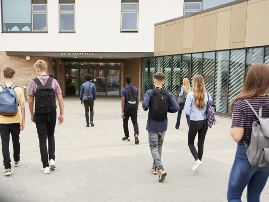 Photo of many young people walking into a building