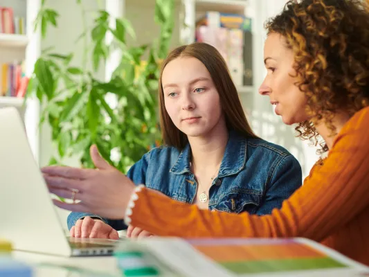 Youth and adult working at a laptop together