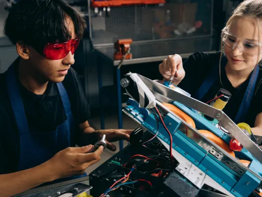 Two youth working on an industrial job site