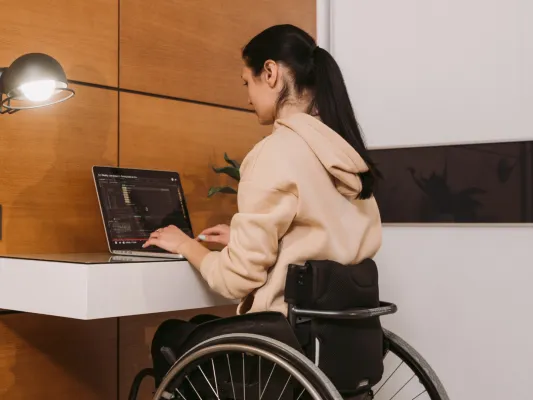 Young woman in a wheelchair working at a computer