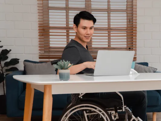 Young man in a wheelchair working at a computer
