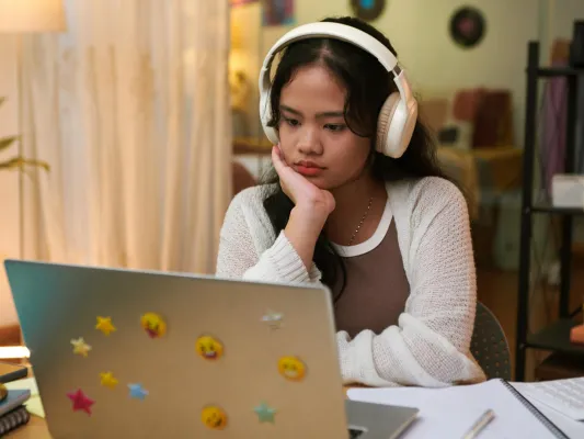 Teen watching videos on a laptop