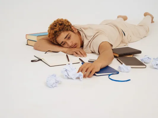 Image of stressed student laying on books