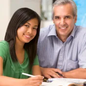 Girl working in school near a teacher