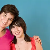 A woman hugs her daughter