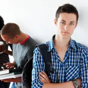 Young man standing alone in hallway