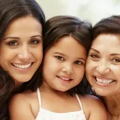 A mother, child, and grandmother smiling