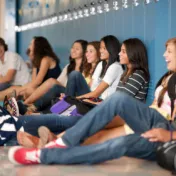 Group of teens sitting in school hallway