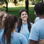 A young group of people talk in a group at a common event.