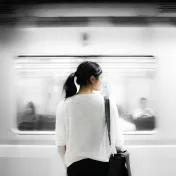 Woman waits for train in work attire