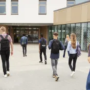 Photo of many young people walking into a building