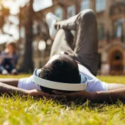 Young man laying in grass with headphones on 