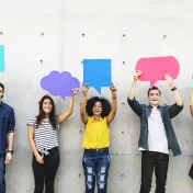 Photo of five youth holding up thought and comment bubbles