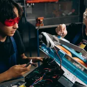 Two youth working on an industrial job site