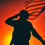 Silhouette of a soldier saluting and holding a flag