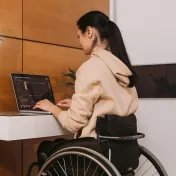 Young woman in a wheelchair working at a computer