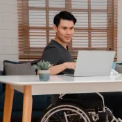 Young man in a wheelchair working at a computer