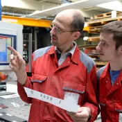 Teen and adult looking at a computer on a job site