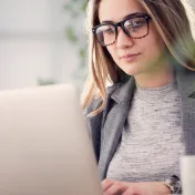 Young woman with glasses working at a laptop