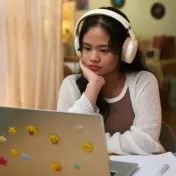 Teen watching videos on a laptop
